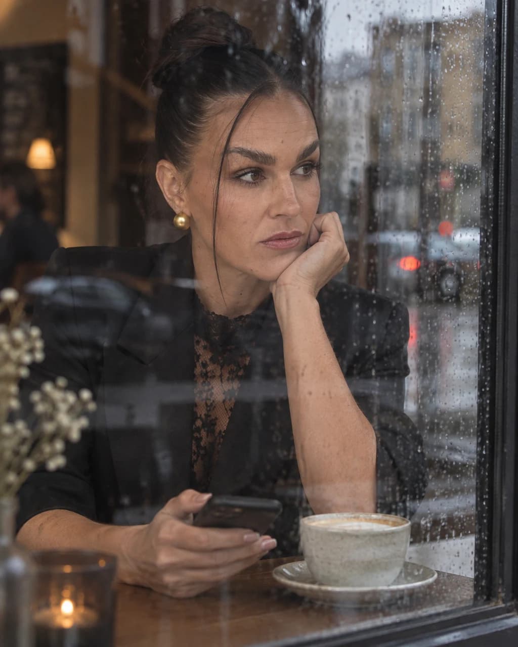 Sandra seated beside a café window.